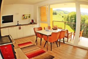 a kitchen and dining room with a table and a balcony at Suiten am Simmhof in Leutschach