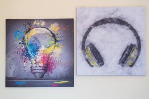 two paintings of a pair of headphones on a wall at Travelershome Ciampino Apartment in Ciampino