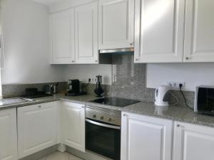 a white kitchen with white cabinets and a stove top oven at Clube Nautilus Apartment in Porches
