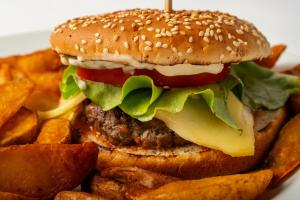 een hamburger en frietjes op een bord bij Hunter Vip in Reghin
