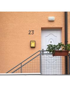a building with a door with a plant in front of it at Apartmani 23 in Novi Pazar