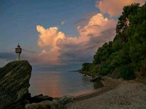 ein Leuchtturm auf einem Felsen neben dem Meer in der Unterkunft Alexandra Studios 2 in Alonnisos Altstadt + 4 Fotos