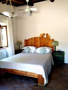 a bedroom with a large bed with a wooden headboard at Locanda Rosati in Orvieto