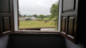 una ventana abierta con vistas a un campo en Pazo de Laia, en Palas de Rei 
