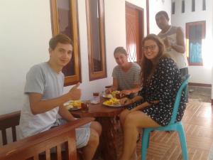 een groep mensen die rond een tafel eten bij Riung Guesthouse in Riung