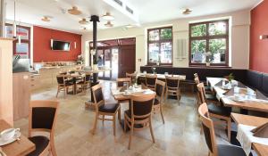 ein Restaurant mit Tischen und Stühlen und einer Küche in der Unterkunft Port Inn Hotel in Eichwalde