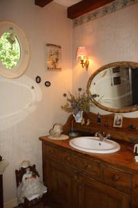 a bathroom with a sink and a mirror at petite maison berrichonne in Chârost
