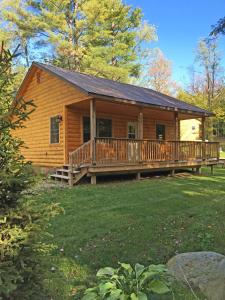 Cabaña de madera con porche grande y terraza en Sterling Ridge Resort, en Jeffersonville