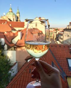 
a person holding a glass of wine in front of a building at Alchymist Grand Hotel and Spa in Prague
