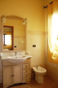 a bathroom with a sink and a mirror and a toilet at Agriturismo Poggio Campana in San Donato