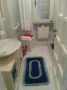 a bathroom with a sink and a blue rug on the floor at CASA ELEGANTE in Martinsicuro