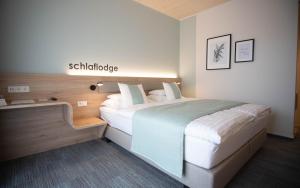 ein Schlafzimmer mit einem Bett und einem Schild, das Schizophrenie liest in der Unterkunft Donau Lodge in Ybbs an der Donau