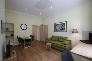 ウィーンにあるVienna Gold Apartments - contactless check inのリビングルーム(緑のソファ、テーブル付)