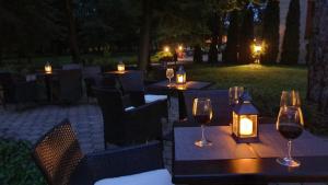 una mesa con copas de vino y una vela en ella en Főnix Medical Wellness Resort en Csitár