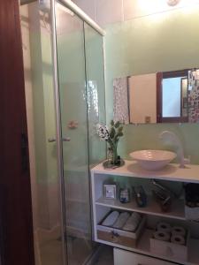 Un baño con ducha de cristal y lavabo. en Teixeira e Souza, en Cabo Frío 36 fotos más