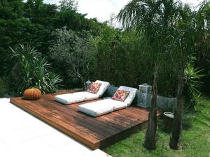 eine Holzterrasse mit zwei Sofas, die darauf sitzen in der Unterkunft Casa Sestina - Logement indépendant dans belle propriété avec piscine in Canohès