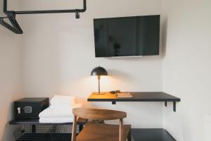 倫敦的住宿－D8 - Shoreditch，客房设有一张桌子、一台电视和一张凳子