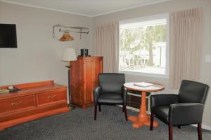 una camera d'albergo con due sedie, un tavolo e una finestra di Admiral Motel a Lake George