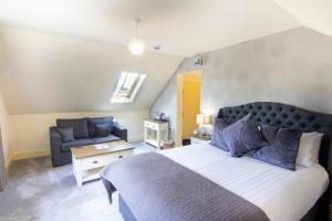 a bedroom with a large bed and a couch at The Charlton Arms in Ludlow