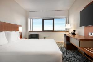 リスボンにあるRamada by Wyndham Lisbonの大きなベッドと机があるホテルの部屋 +37枚の写真