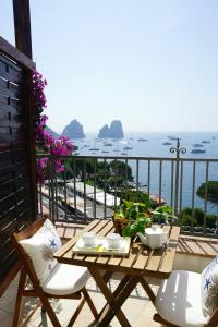 a table on a balcony with a view of the ocean at La Finestra sui Faraglioni in Capri