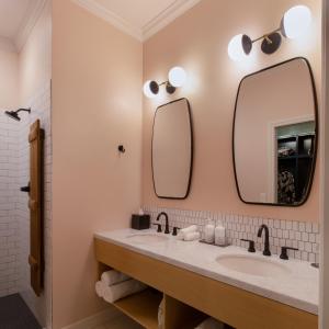 a bathroom with two sinks and a mirror at Atticus Hotel in McMinnville