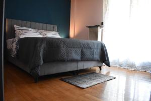 a bedroom with a bed and a rug on a wooden floor at Katzen Room by the Metro in Athens