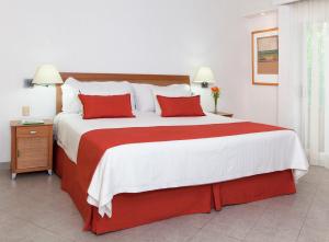 a bedroom with a large bed with red pillows at Hotel Viva Villahermosa in Villahermosa