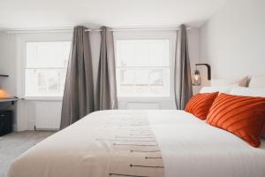 duże białe łóżko w sypialni z 2 oknami w obiekcie D8 - Shoreditch w Londynie