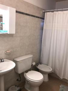 y baño con aseo blanco y lavamanos. en OLÍMPICO en Concepción del Uruguay