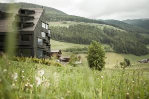 a building on a hill with a grassy field at Bühelwirt in San Giacomo