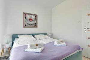 a bedroom with a bed with two towels on it at Wild Island Suite in Gdańsk