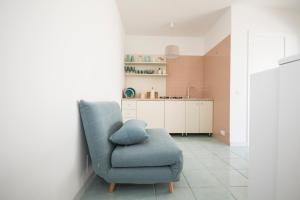 sala de estar con silla azul y cocina en Il mare di fronte “Casa Smeraldo”, en Savelletri di Fasano 26 fotos más