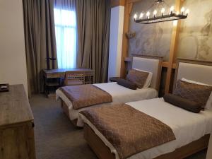a hotel room with two beds and a desk at Shirvanshah Hotel in Baku