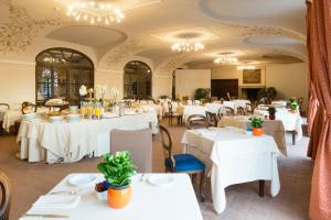 un restaurant avec des tables, des chaises et des lustres blancs dans l'établissement Casa Munfrà, à Cioccaro