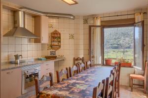 una cocina con una mesa y sillas largas y una ventana en Casa Rural Al-Mofrag y Apartamentos El Mirador de Monfragüe, en Villarreal de San Carlos