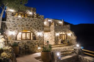 a stone building with lights on it at night at To Spiti mas in Sougia