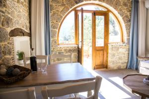 a dining room with a table and a large window at To Spiti mas in Sougia