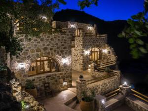 a stone building with lights on it at night at To Spiti mas in Sougia