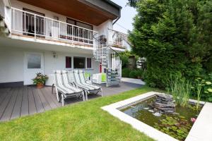 un patio con sedie e un laghetto di fronte a una casa di FeWo Sommerhalde a Althütte