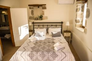 a bedroom with a bed with pillows on it at To Spiti mas in Sougia