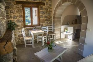 a room with a table and chairs in a building at To Spiti mas in Sougia