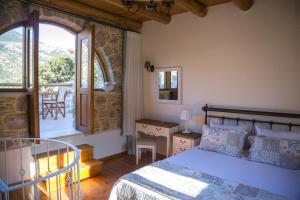 a bedroom with a bed and a view of a balcony at To Spiti mas in Sougia