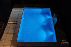 a large blue swimming pool in a dark room at Complejo Paradise in La Rioja