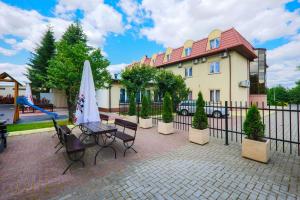 a house with a playground and a table with a umbrella at Hotel Restauracja Leliwa in Przeworsk
