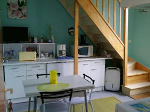 a table and chairs in a kitchen with a staircase at Ellias in Pont-lʼAbbé