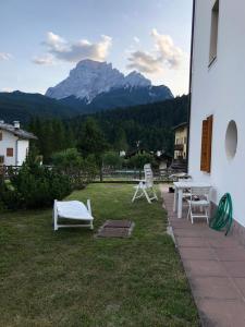 um pátio com uma mesa e cadeiras e uma montanha em Casa bianca em San Vito di Cadore
