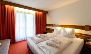 A bed or beds in a room at Hotel Mirabell