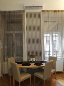 a dining room with a table and chairs and windows at West10 STAR City Center in Budapest