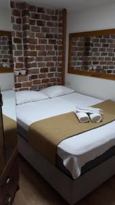 um quarto com 2 camas e uma parede de tijolos em suit cihangir em Istambul